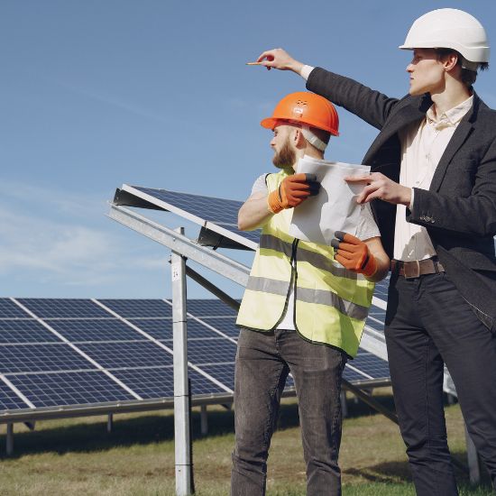 Dois homens em um campo de geração de energia solar